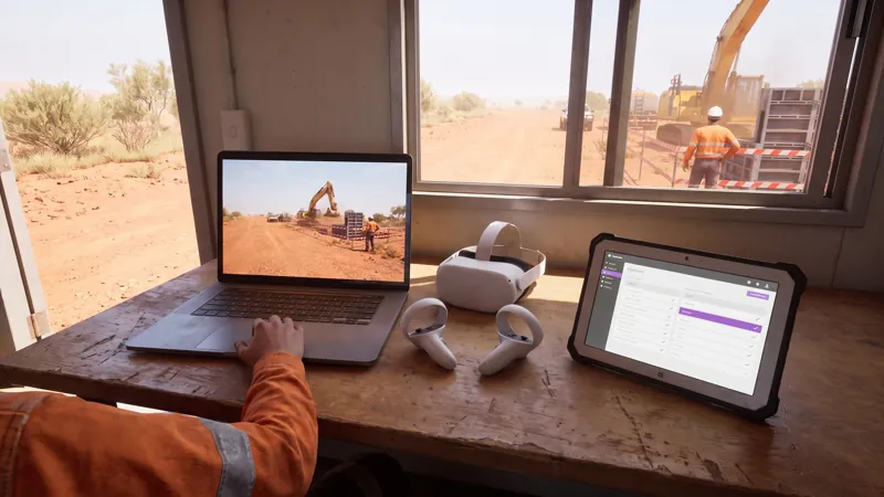 A site office desk with the module running on a laptop, a headset beside it and the dashboard on a tablet